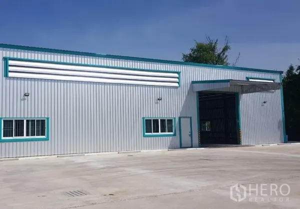 Warehouse for rent in Mueang Nonthaburi, Nonthaburi - Modern steel-clad warehouse exterior with wide loading door and a large concrete yard.