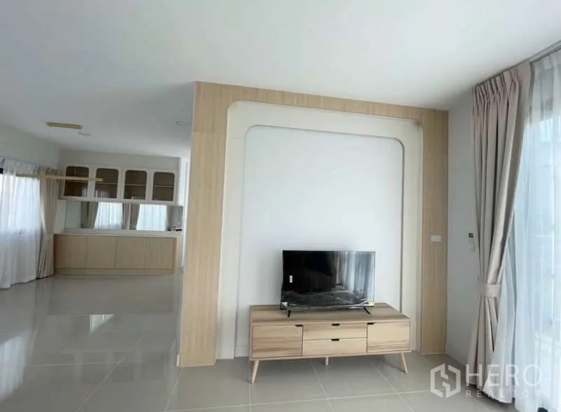 Detached House for rent in Bang Phli, Samut Prakan - Open-plan living area with TV console and view toward pantry and kitchen.