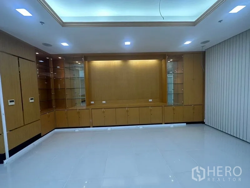 Office Space for rent in Suan Luang, Bangkok - Feature wall with illuminated glass display shelves and wood cabinets in an office setting.