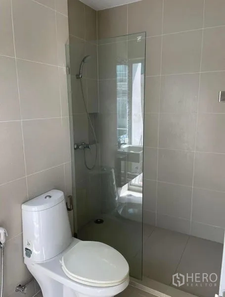 ทาวน์เฮาส์ ให้เช่าในSuan Luang, Bangkok - ห้องน้ำสไตล์โมเดิร์น กระเบื้องสีเบจ ฝักบัวกั้นกระจก และโถสุขภัณฑ์สีขาว