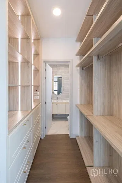Detached House for sale in Saphan Sung, Bangkok - Walk-in closet with built-in shelves leading to an ensuite bathroom.