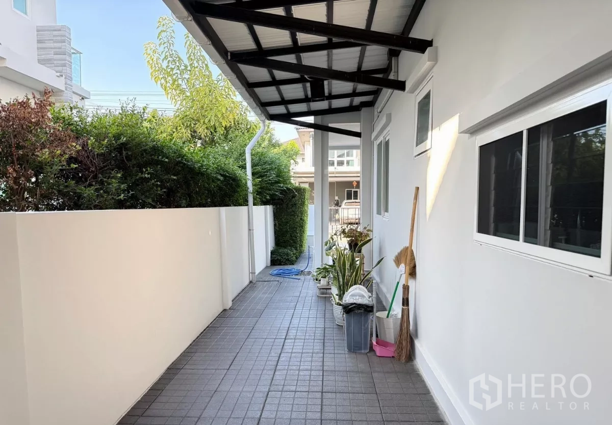 Detached House for rent in Prawet, Bangkok - Covered service walkway along side of house with plants and storage