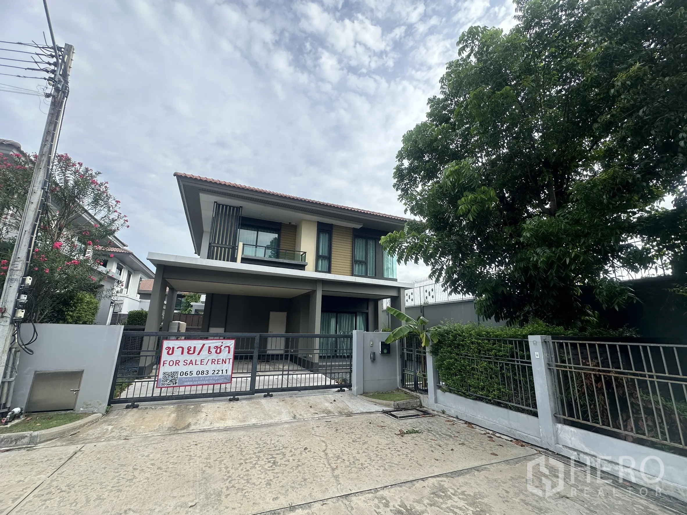 独栋房屋 for rent or sale in Lam Luk Ka, Pathum Thani - 房屋正立面，带入户大门与成树。