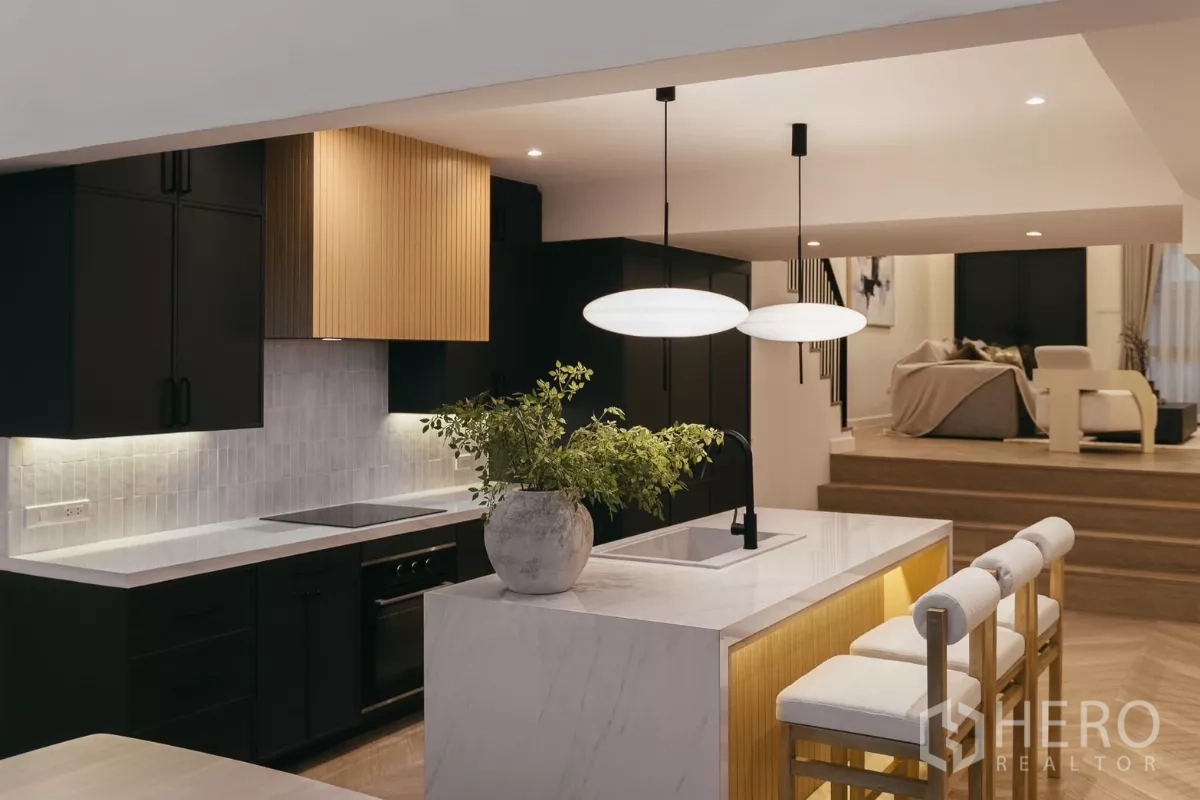 联排别墅 出租在Watthana, Bangkok - 设计师厨房，白色大理石中岛、黑色柜体与吊灯。