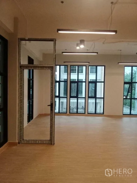 สำนักงานที่บ้าน ให้เช่าในBang Kapi, Bangkok - มุมมองภายในที่มีหน้าต่างสูงและประตูกระจกเชื่อมต่อพื้นที่ถัดไป.