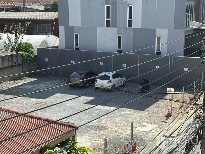 Home Office for rent in Phra Khanong, Bangkok - View of the on-site gravel car park with several vehicles next to a modern facade.