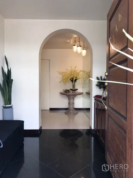 บ้าน ให้เช่าในPhra Khanong, Bangkok - ประตูไม้ทางเข้าสู่โถงโค้ง พร้อมแจกันดอกไม้ตกแต่ง