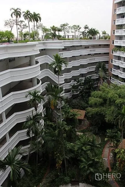 Condominium for sale in Wang Thonglang, Bangkok - Walkways and tall palms surrounding the condominium’s central garden.