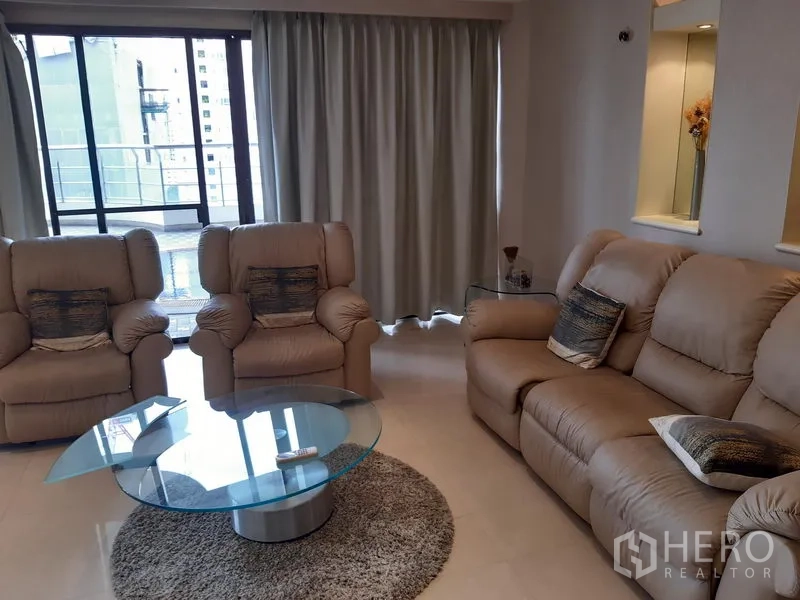 คอนโด ให้เช่าในKhlong Toei, Bangkok - มุมนั่งเล่นอบอุ่น โซฟารีไคลเนอร์สามตัว ผ้าม่านสูงจรดเพดาน และประตูกระจกสไลด์สู่เทอเรซ