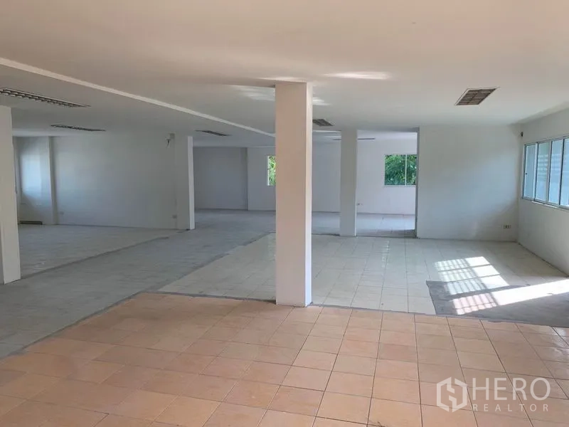 办公空间 出租在Huai Khwang, Bangkok - 开放式办公区，分区瓷砖地面，多面采光与中央立柱。