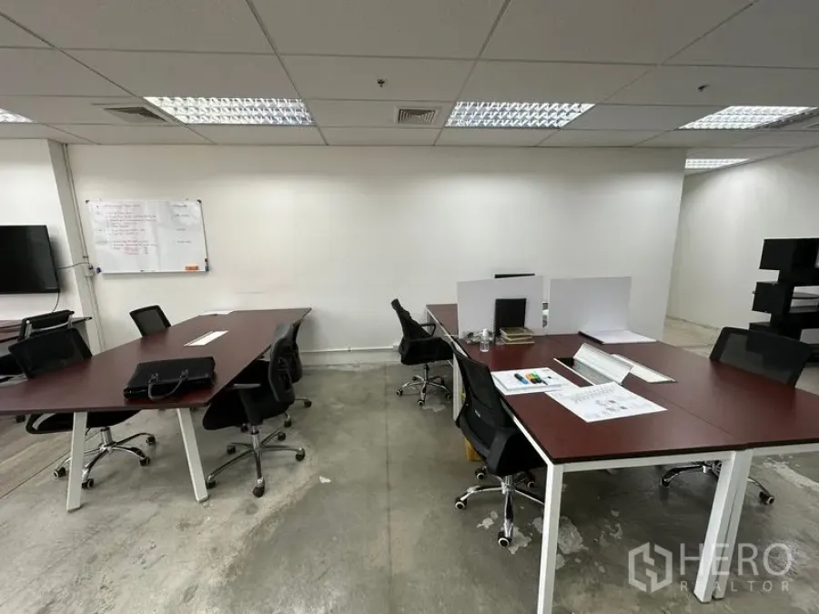 Office Space for rent in Khlong Toei, Bangkok - Shared workspace with meeting tables, swivel chairs and a wall whiteboard.