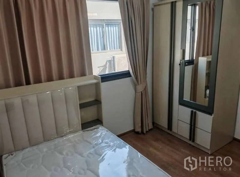 ทาวน์เฮาส์ ให้เช่าในBang Phli, Samut Prakan - ห้องนอนรอง เตียงเดี่ยว ตู้เสื้อผ้ากระจกเงา ผ้าม่านสีเบจ และพื้นไม้