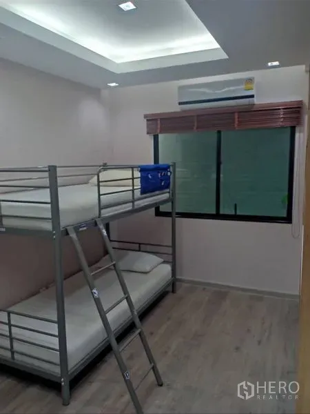Detached House for rent in Thanyaburi, Pathum Thani - Bright bedroom with a metal bunk bed, window blinds, and wood-style flooring.