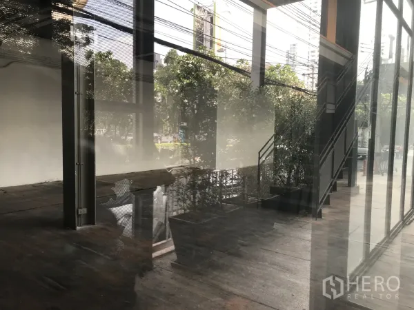 零售空间 出租在Watthana, Bangkok - 店内开放格局，层高充裕，金属楼梯与临街玻璃立面
