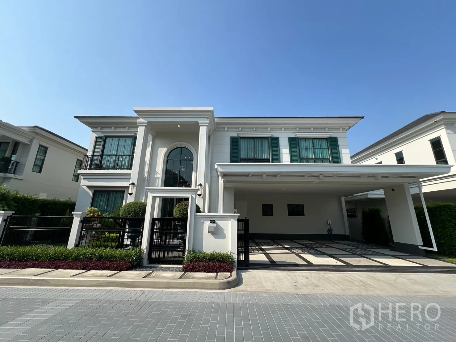 บ้านเดี่ยว for rent in Bang Phli, Samut Prakan - ภาพด้านหน้าบ้านเดี่ยวสองชั้นสีขาว บานหน้าต่างสีเขียว พร้อมรั้วหน้าบ้าน