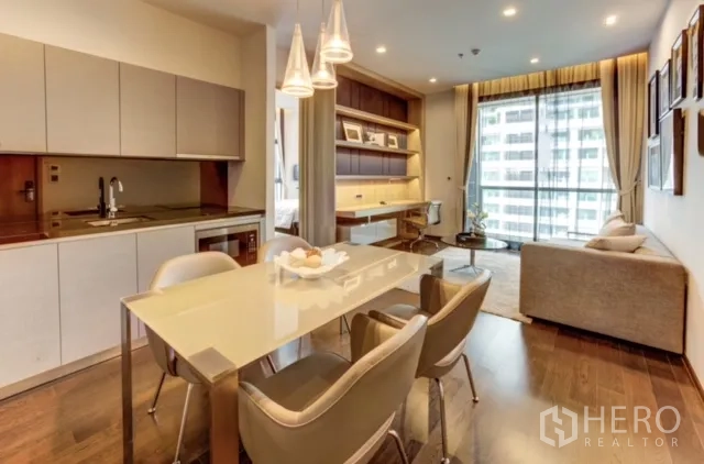 Condominium for rent or sale in Watthana, Bangkok - Open-plan living with modern kitchen, dining table and floor-to-ceiling windows at The XXXIX by Sansiri.