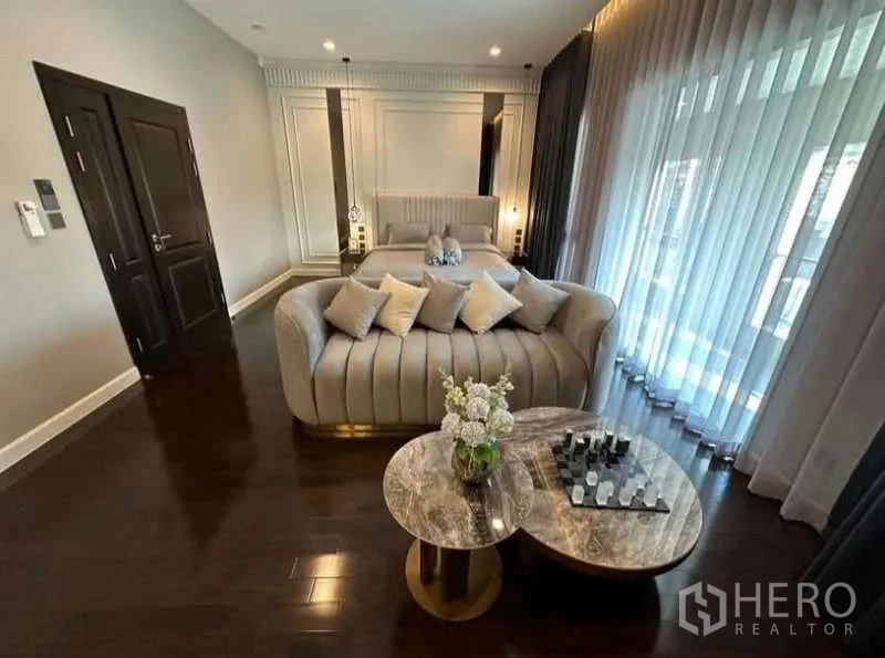 บ้าน ให้เช่าในLat Krabang, Bangkok - ห้องนอนหรู โซฟาท้ายเตียง โต๊ะหินอ่อน และผ้าม่านสูงจรดเพดาน