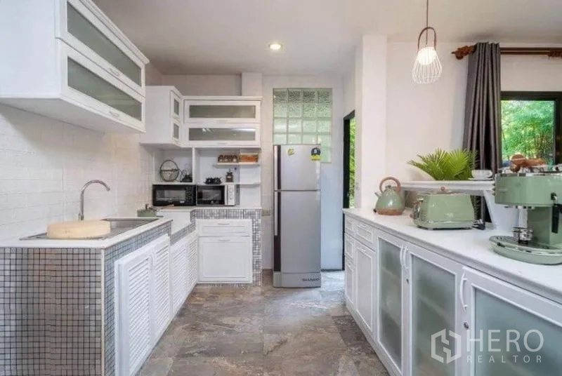 Detached House for rent in Ratchathewi, Bangkok - White open kitchen with mosaic counters and stainless refrigerator.