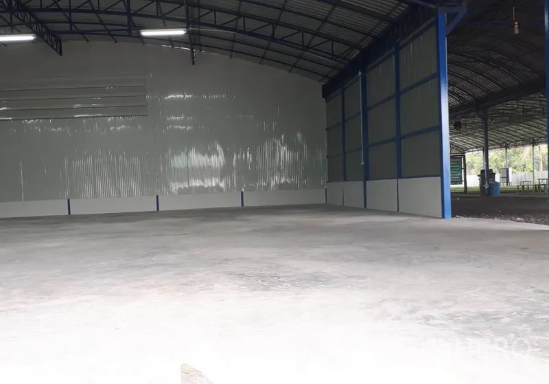 Warehouse for rent in Nong Chok, Bangkok - Warehouse entrance with sliding door opening to a covered loading bay and expansive concrete yard.
