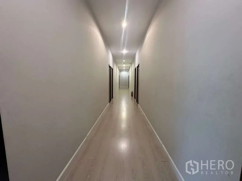 Home Office for rent in Chatuchak, Bangkok - Long well-lit corridor with multiple room doors on both sides.