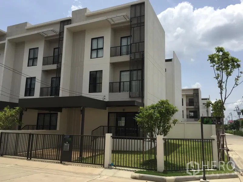 Townhouse for rent or sale in Saphan Sung, Bangkok - Three-storey modern townhouse exterior with gated front lawn and carport in Saphan Sung, Bangkok.