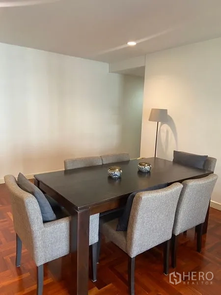Condominium for rent in Pathum Wan, Bangkok - Dining area with six upholstered chairs and modern lighting.