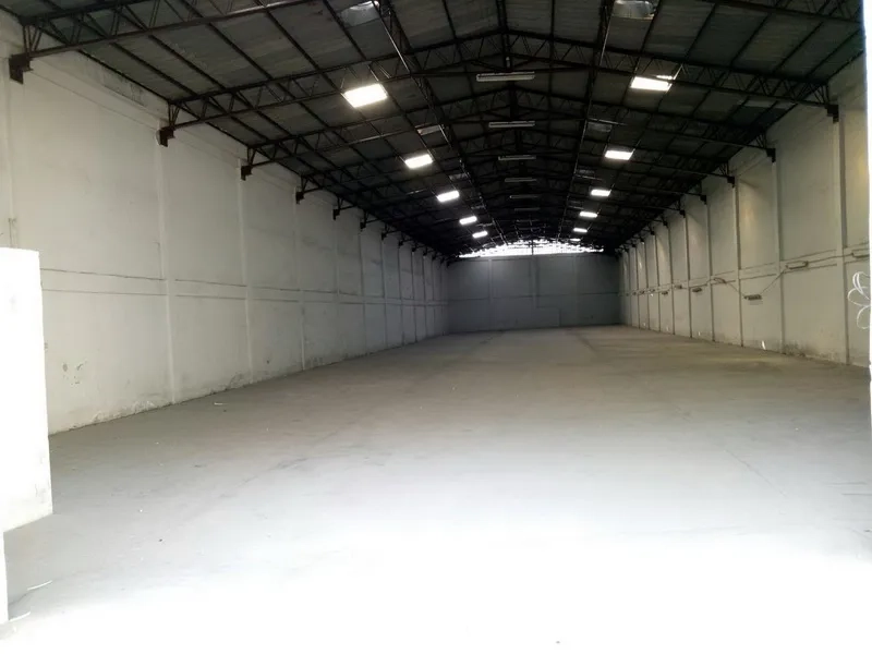 货栈 出租在Khlong Toei, Bangkok - 宽敞仓库内部，高钢结构屋顶、白色墙面与混凝土地面，天窗采光充足。
