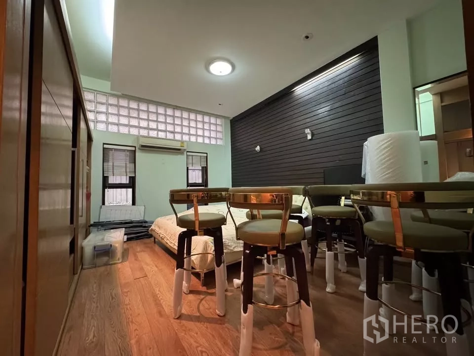 店屋 出租在Bang Rak, Bangkok - 多功能房，木地板与玻璃砖高侧窗，摆放高脚椅与低床。