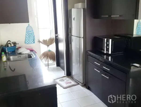 Detached House for rent in Wang Thonglang, Bangkok - Fitted kitchen with dark cabinetry, black granite countertops, windowed door and stainless appliances.