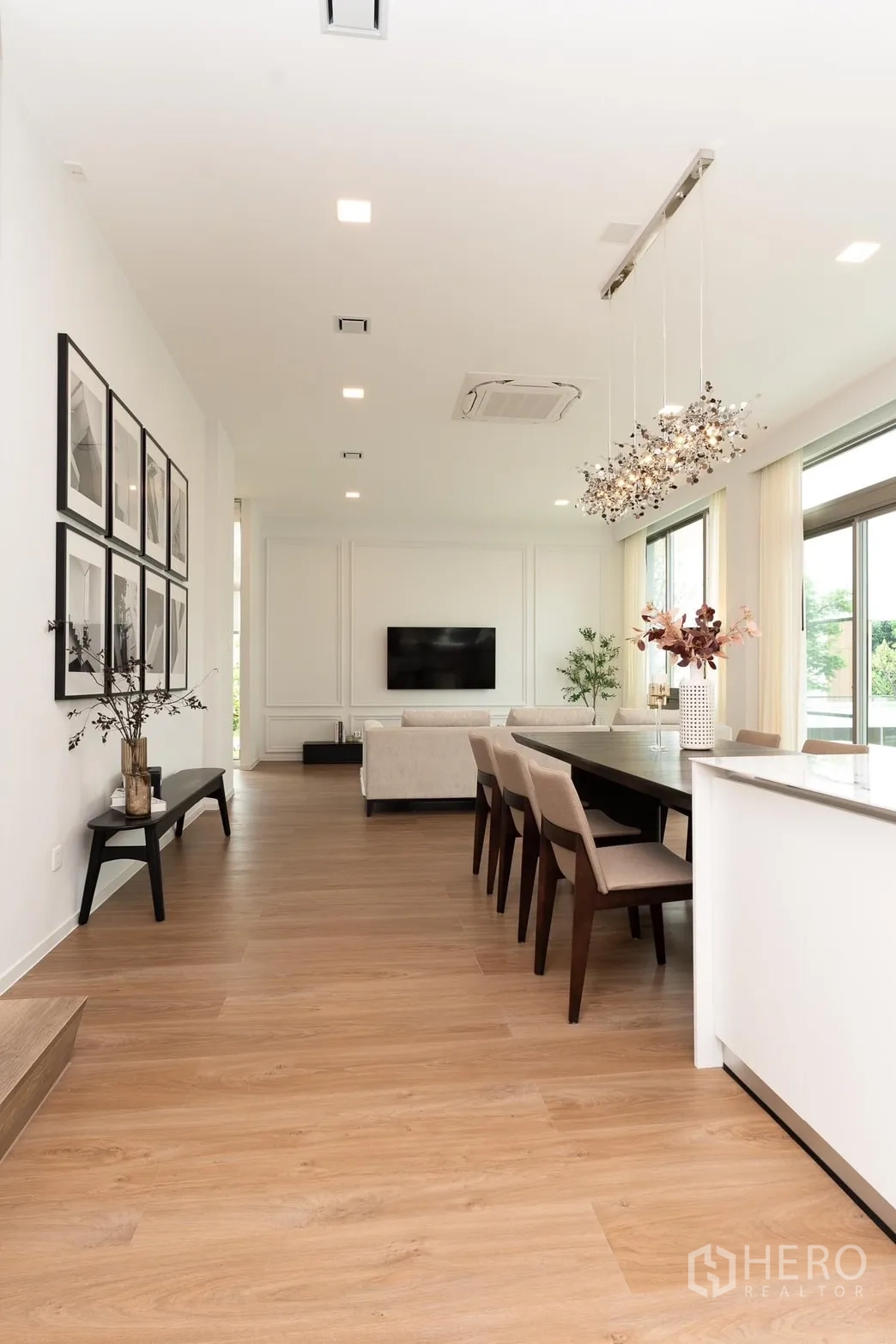 Detached House for rent in Saphan Sung, Bangkok - Dining space with long table, wood floors and view to a cozy living room