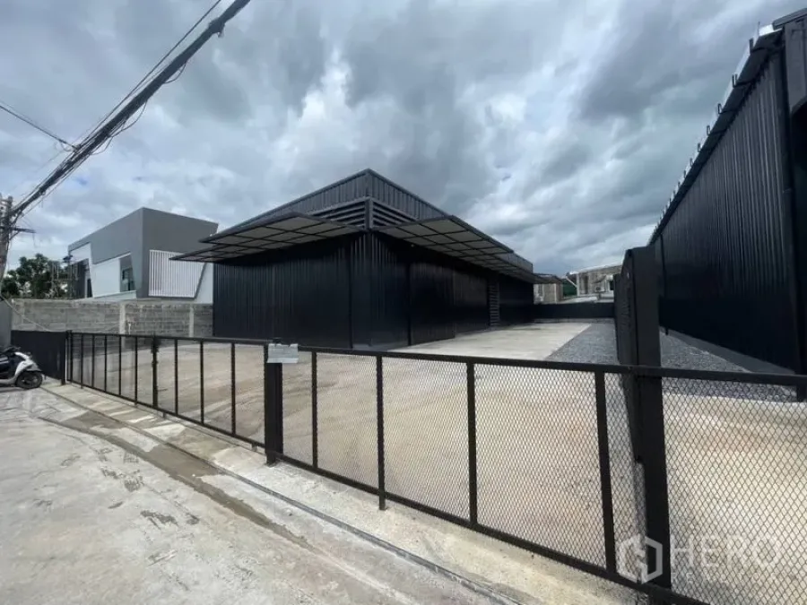 คลังสินค้า ให้เช่าในLat Phrao, Bangkok - ประตูรั้วโกดังกว้างและลานคอนกรีตขนาดใหญ่หน้าพื้นที่ พร้อมกันสาดขนถ่ายสินค้า.