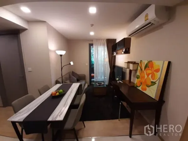 คอนโด ให้เช่าหรือขายในWatthana, Bangkok - ห้องนั่งเล่นแบบโอเพ่นแพลน มีโต๊ะทานข้าว ชั้นวางทีวี โต๊ะทำงาน และประตูกระจกออกระเบียง ใกล้เอกมัย