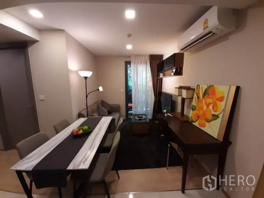 คอนโด ให้เช่าหรือขายในWatthana, Bangkok - ห้องนั่งเล่นแบบโอเพ่นแพลน มีโต๊ะทานข้าว ชั้นวางทีวี โต๊ะทำงาน และประตูกระจกออกระเบียง ใกล้เอกมัย