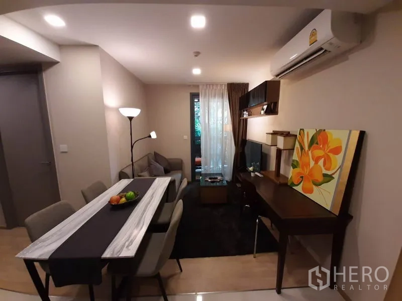 คอนโด ให้เช่าหรือขายในWatthana, Bangkok - ห้องนั่งเล่นแบบโอเพ่นแพลน มีโต๊ะทานข้าว ชั้นวางทีวี โต๊ะทำงาน และประตูกระจกออกระเบียง ใกล้เอกมัย