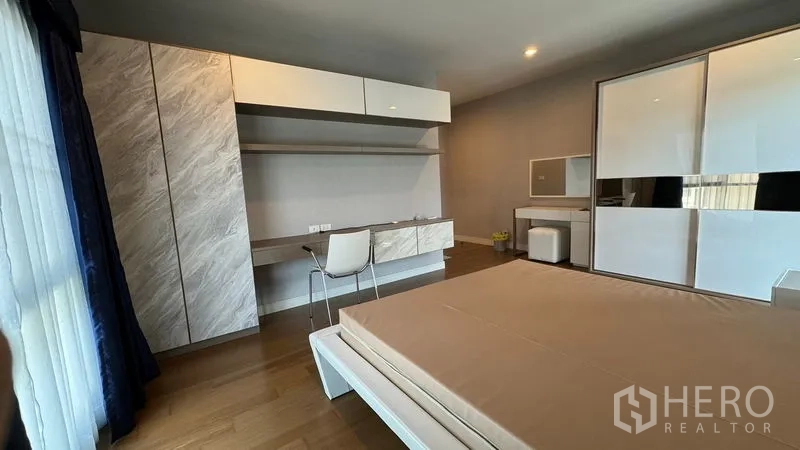 Detached House for rent in Prawet, Bangkok - Bedroom showing built-in cabinets, long desk and sliding wardrobe.