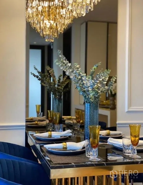 公寓 出租 - 餐桌细节：尤加利花瓶、金边水杯与吊灯倒影。