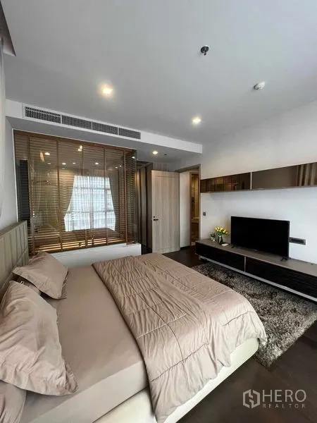 คอนโด ให้เช่าหรือขายในWatthana, Bangkok - มุมมองห้องนอนใหญ่ พร้อมชั้นวางยาว ทีวี และพื้นไม้สีเข้ม