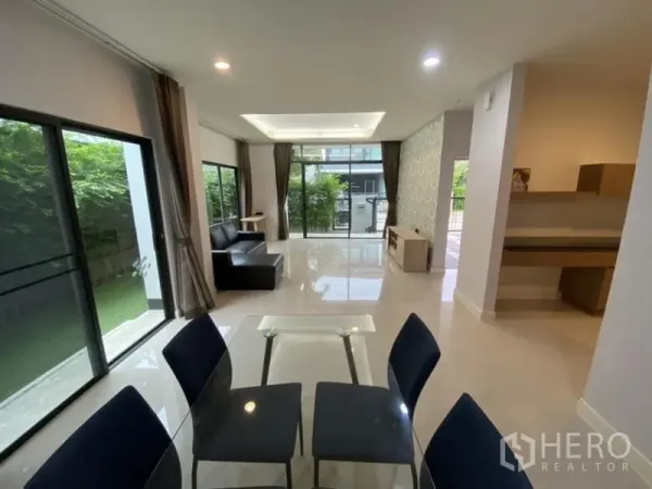 Detached House for rent in Bang Kapi, Bangkok - Bright open-plan living and dining area with large windows and sliding doors to the garden.
