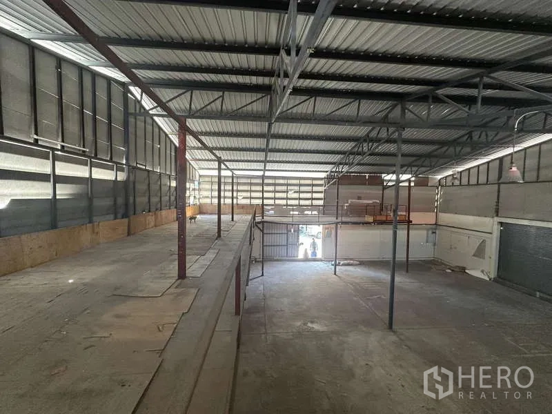 Warehouse for rent in Suan Luang, Bangkok - Long mezzanine storage platform beneath a steel roof structure inside the warehouse.