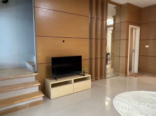 Townhouse for rent in Wang Thonglang, Bangkok - Wood-paneled TV wall beside staircase and glass partition