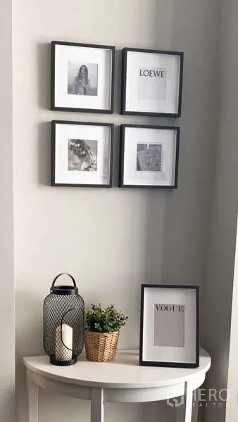 คอนโด ให้เช่าในWatthana, Bangkok - มุมตกแต่งทางเข้าพร้อมกรอบรูปสี่กรอบ โคมเทียน และต้นไม้กระถางบนโต๊ะคอนโซลสีขาว