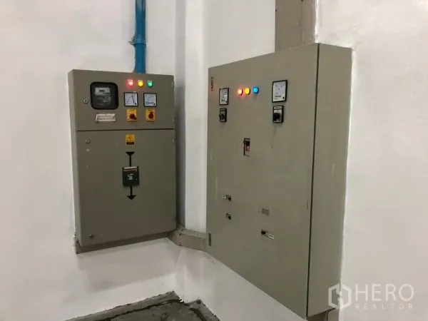 Warehouse for rent in Pak Kret, Nonthaburi - Industrial electrical control panels mounted on a white wall, indicating three‑phase power.