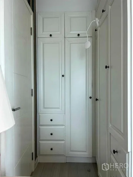 Condominium for sale in Huai Khwang, Bangkok - Built-in white wardrobes and storage in a compact hallway.