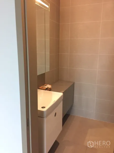 คอนโด ให้เช่าในPathum Wan, Bangkok - ห้องน้ำปูกระเบื้องสีเบจ เคาน์เตอร์อ่างล้างหน้าลอยตัว และกระจกยาว