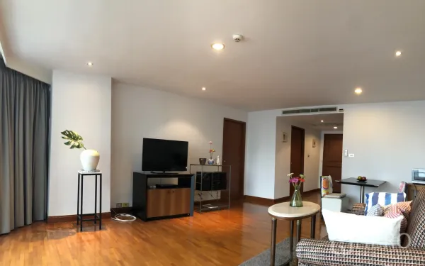 คอนโด ให้เช่าในKhlong Toei, Bangkok - ห้องนั่งเล่นสว่าง พื้นไม้ ตู้ทีวีและแจกันต้นไม้ ในคอนโดใกล้อโศก