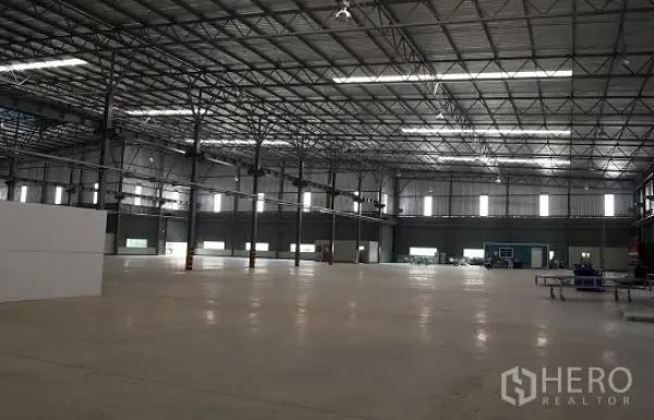 工厂 出租在Si Racha, Chon Buri - 宽敞的厂房内部，高钢结构屋顶与天窗，抛光混凝土地面。