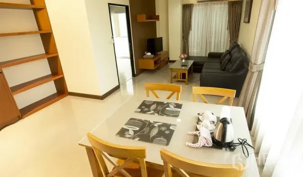 房间 出租在Khlong Toei, Bangkok - 餐桌面向客厅，可见电视柜与内置层架