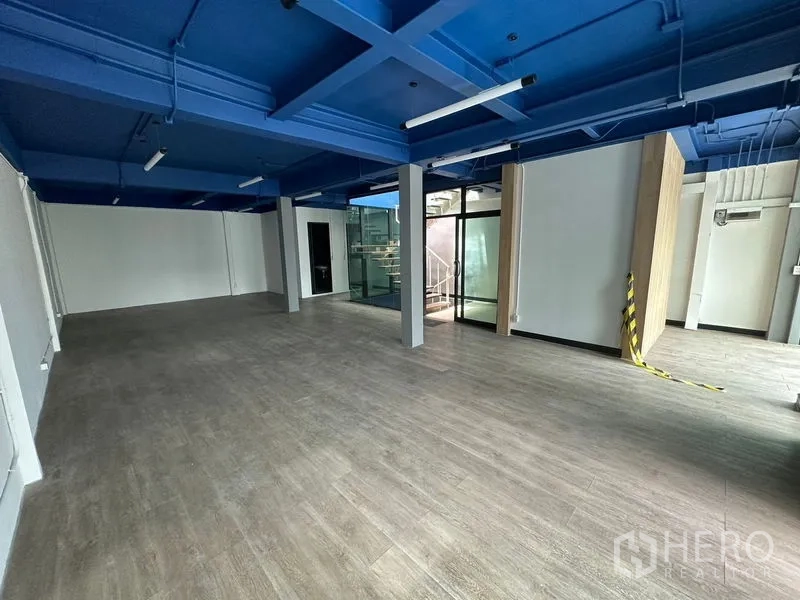 สำนักงาน ให้เช่าในWatthana, Bangkok - ชั้นสำนักงานกว้าง มีเสากลาง ประตูกระจก และเพดานโครงสีน้ำเงินแบบเปิด