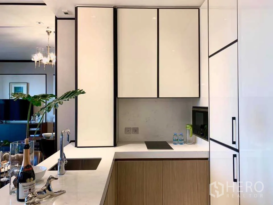 คอนโด ให้เช่าในKhlong Toei, Bangkok - ครัวรูปตัว U ตู้เก็บของสีขาว ท็อปหิน เตาไฟฟ้าแบบบิวท์อิน และพื้นที่จัดเก็บ