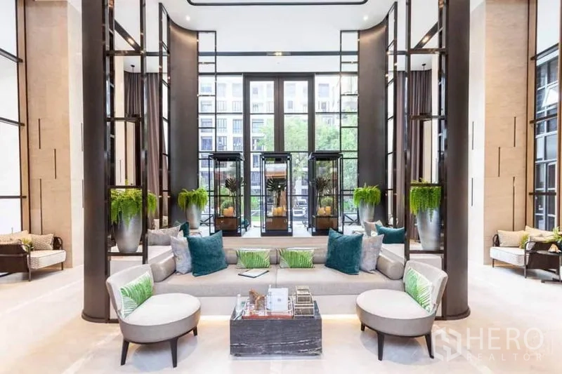 คอนโด ให้เช่าในWatthana, Bangkok - ล็อบบี้เพดานสูง โซฟาขนาดใหญ่ หน้าต่างสูง และตกแต่งด้วยต้นไม้